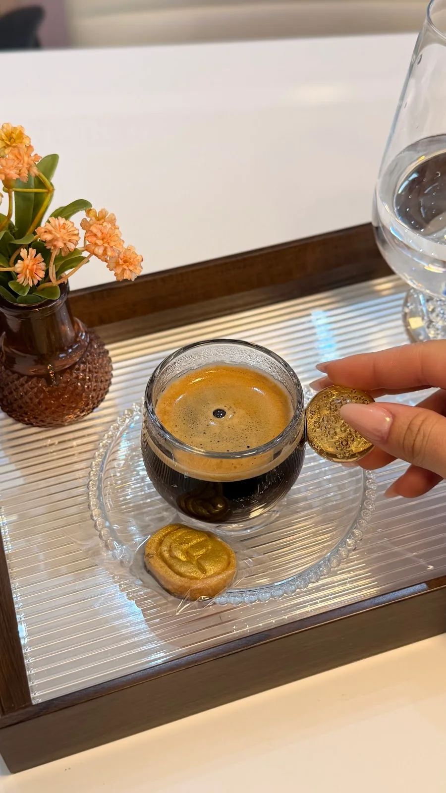 Café servido numa bandeja, com dois biscoitos