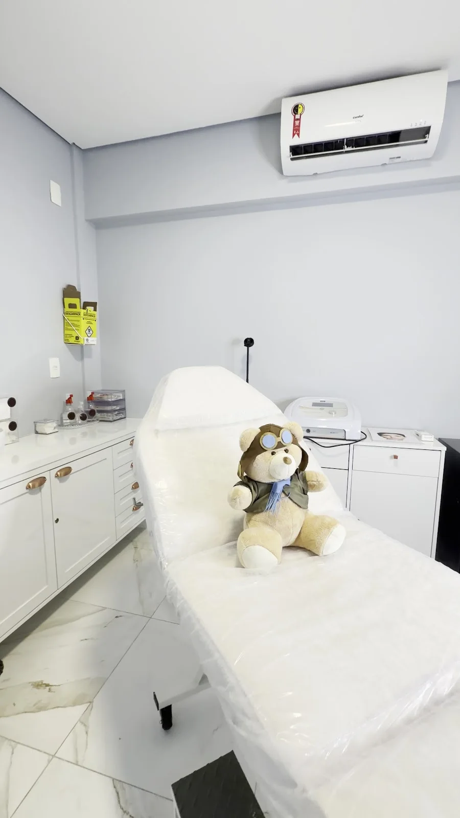 Sala de procedimento com maca e armários brancos
